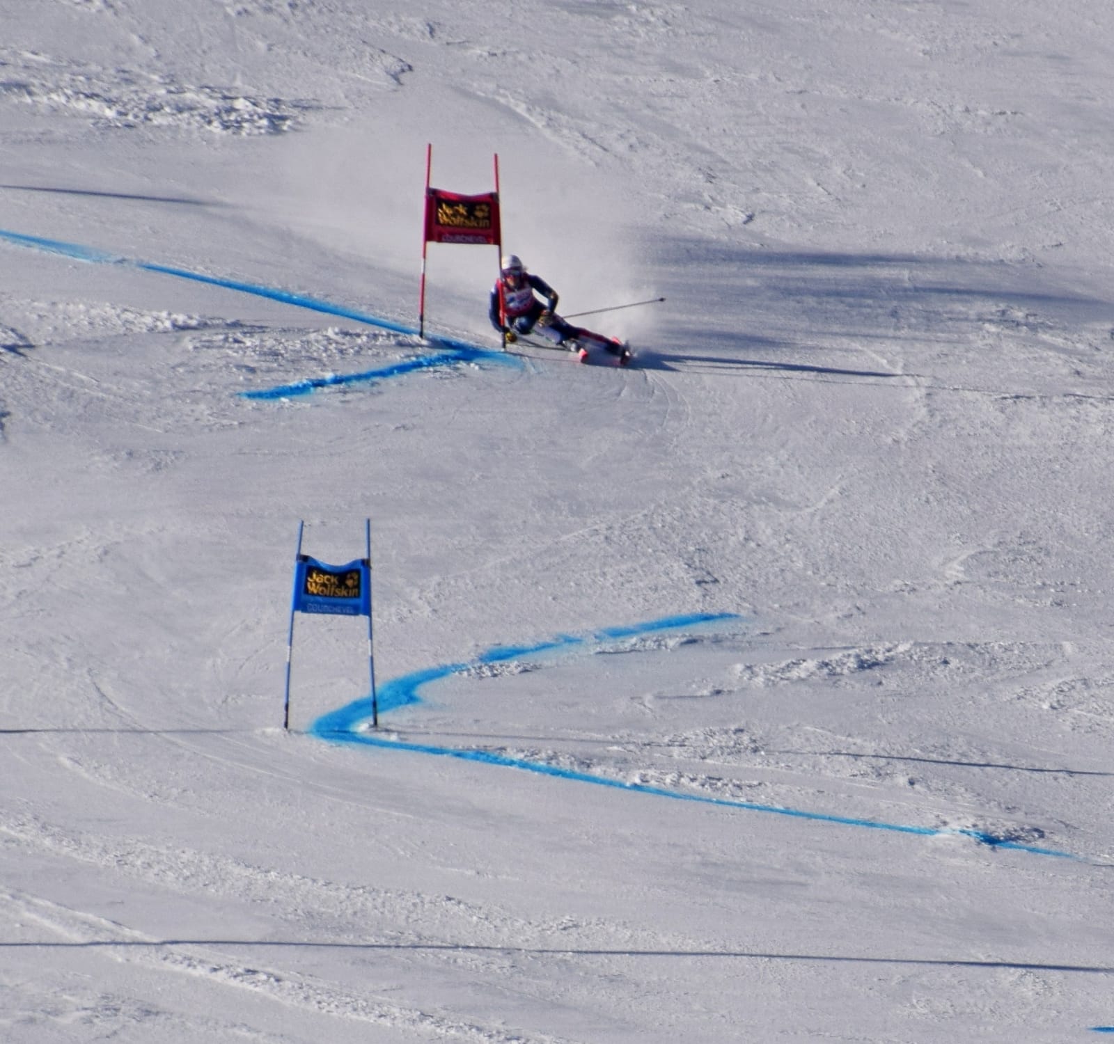 Un skieur en appui sur une piste damée